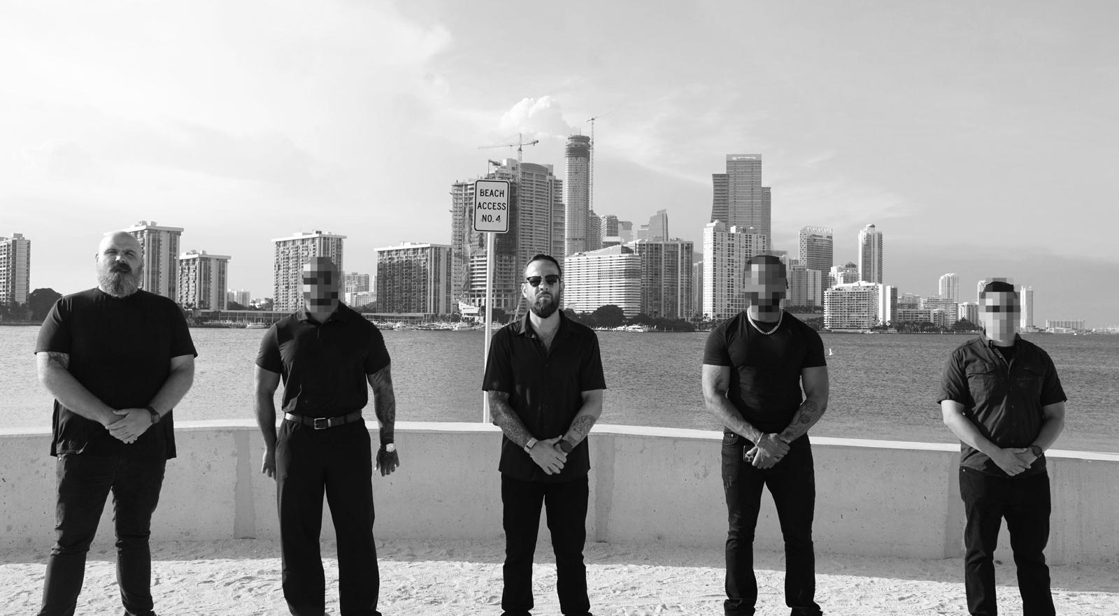 Miami Private Investigations team at Biscayne Bay with the Miami skyline behind them